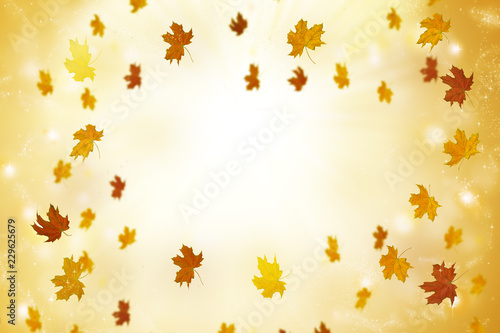 Abstract autumn background with sun rays and flying leaves.