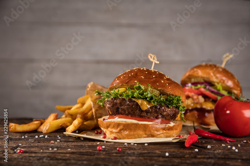 Delicious hamburgers with fries, served on wood