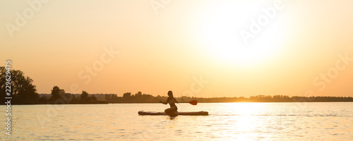 Young sexy woman swimming on stand up paddle board.Water sports , active lifestyle.  © Denis