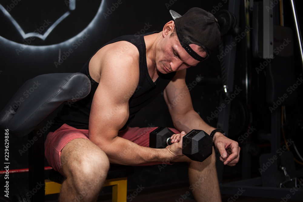man at the gym doing exercise with dumbbells for biceps man at the gym doing exercise with dumbbells for biceps
