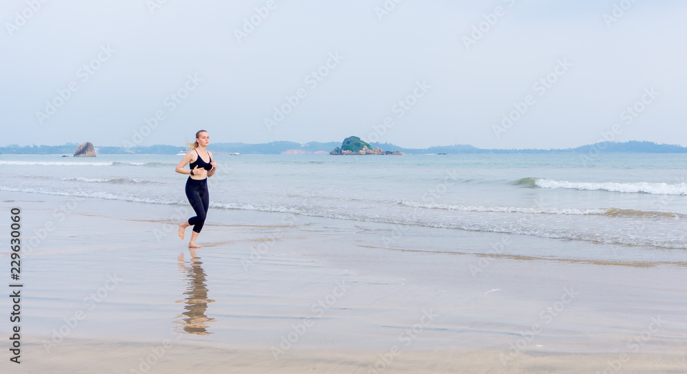 The girl runs along the beach doing sports The girl runs along the beach doing sports