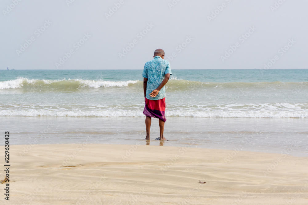 poor Asian man looks at the ocean sea poor Asian man looks at the ocean sea