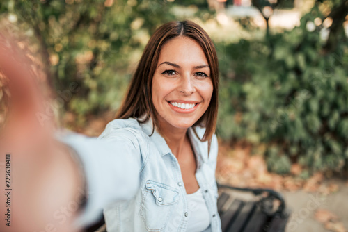Beautiful girl taking selfie in the park.