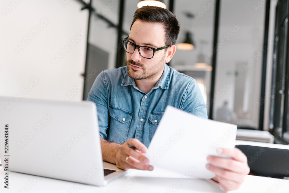 Young man working in modern office. Close-up. Young man working in modern office. Close-up.