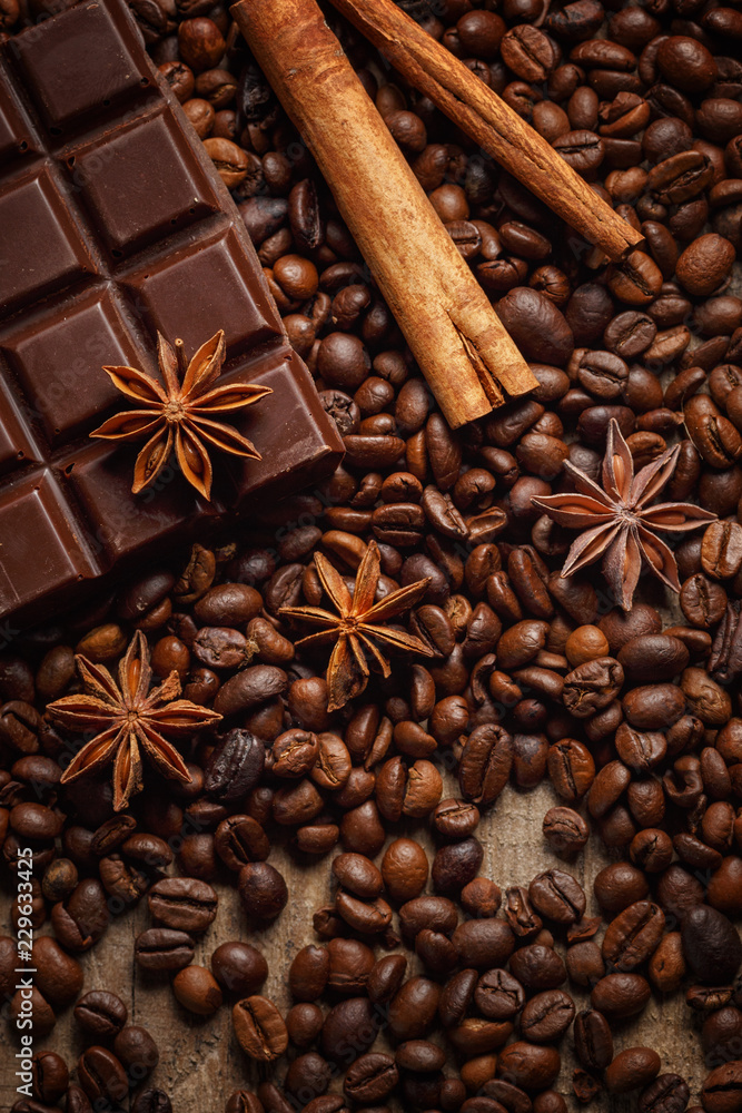 Texture spilling coffee beans, chocolate, cinnamon and cloves. Top view. Copy space. Texture spilling coffee beans, chocolate, cinnamon and cloves. Top view. Copy space.
