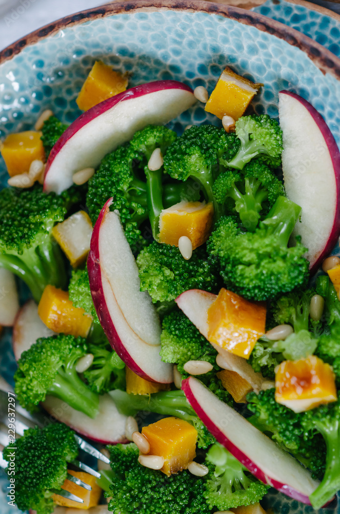 Salad with baked pumpkin, apple, broccoli and pine nuts. Ceramic plates handmade. Rustic style. Salad with baked pumpkin, apple, broccoli and pine nuts. Ceramic plates handmade. Rustic style.