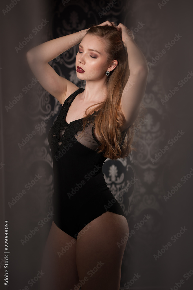 Boudoir photography of a beautiful young lady in black body over dark stylish background Boudoir photography of a beautiful young lady in black body over dark stylish background
