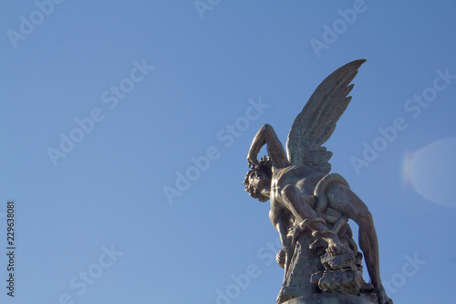 The Fuente del Ángel Caído (Fountain of the Fallen Angel) statue in Retiro Park, Madrid, Spain, representing the devil or Satan falling from heaven. With room for text.