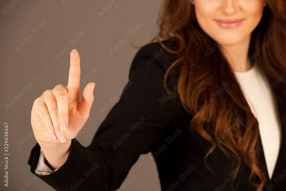 Attractive business woman pressing a virtual button Attractive business woman pressing a virtual button