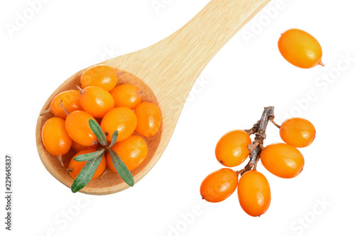 Sea buckthorn. Fresh ripe berry in woden spoon with leaves isolated on white background. Top view. Flat lay pattern photo