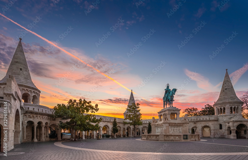 Obraz premium Budapest, Hungary - Fisherman's Bastion (Halaszbastya) and statue of Stephen I. with colorful sky and clouds at sunrise