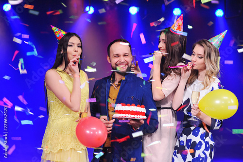 company of cheerful friends in festive hats to celebrate the event. Birthday, new year, party