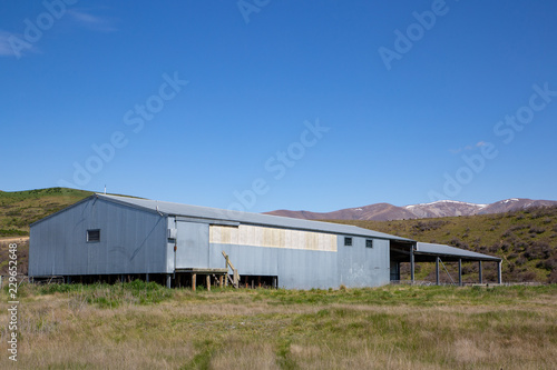 An iron woolshed or shearing shed on a farm in the high country of New Zealand © Sheryl