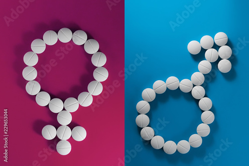 Drugs on a blue and pink background in the form of signs of Venus and Mars. Сoncept of the relations.