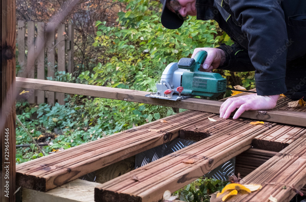 Men 40-50 years. Saws electric circular saw, construction tool in the work. Men 40-50 years. Saws electric circular saw, construction tool in the work.