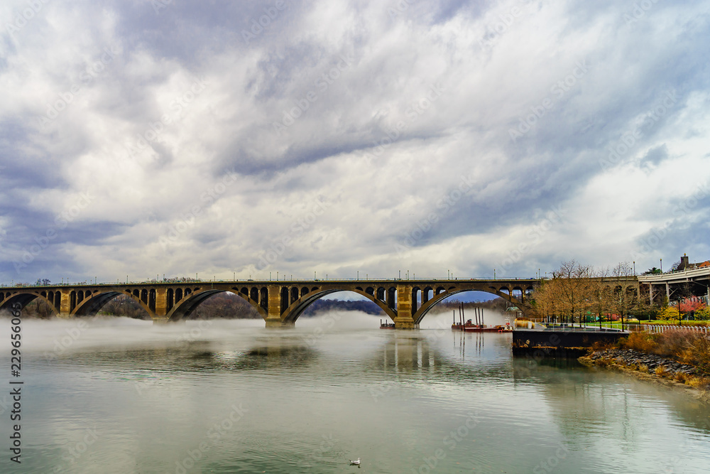 Francis Scott Key Bridge across Potomac River, winter fog on the water.