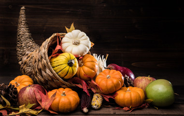 A Thanksgiving holiday decorative cornucopia with pumpkins, squash, leaves etc