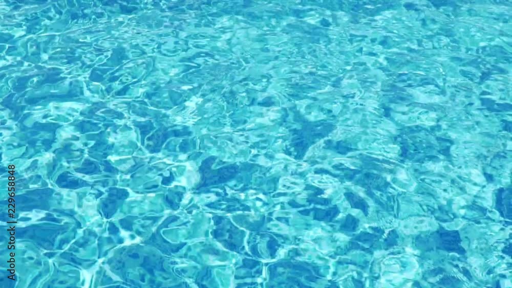 Slow motion background of a pool with wavy clean fresh water at sunset of the day. Reflection of clear blue pool water, flashes. Texture bright turquoise surface of the water in the pool Slow motion background of a pool with wavy clean fresh water at sunset of the day. Reflection of clear blue pool water, flashes. Texture bright turquoise surface of the water in the pool