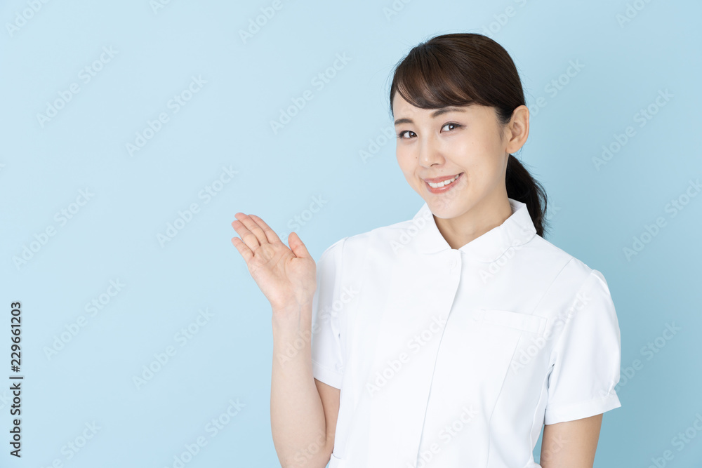 portrait of young asian nurse on blue background portrait of young asian nurse on blue background