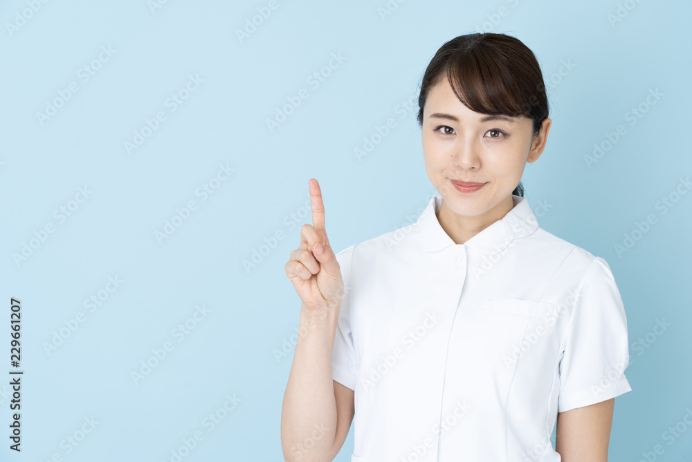 portrait of young asian nurse on blue background portrait of young asian nurse on blue background
