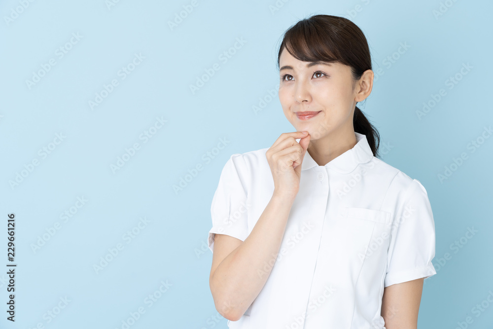 portrait of young asian nurse on blue background portrait of young asian nurse on blue background