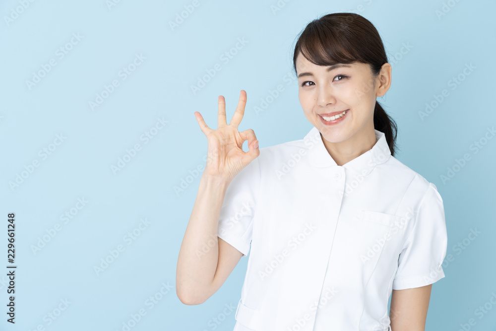 portrait of young asian nurse on blue background portrait of young asian nurse on blue background