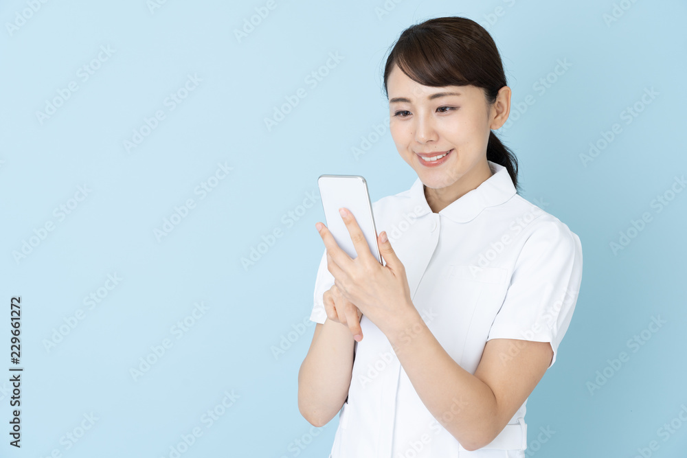 portrait of young asian nurse on blue background portrait of young asian nurse on blue background