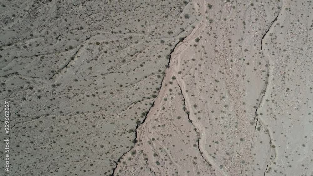 Senital aerial drone scene of dry river between sandy soil with few native vegetation. Catamarca province, Argentina. Senital aerial drone scene of dry river between sandy soil with few native vegetation. Catamarca province, Argentina.