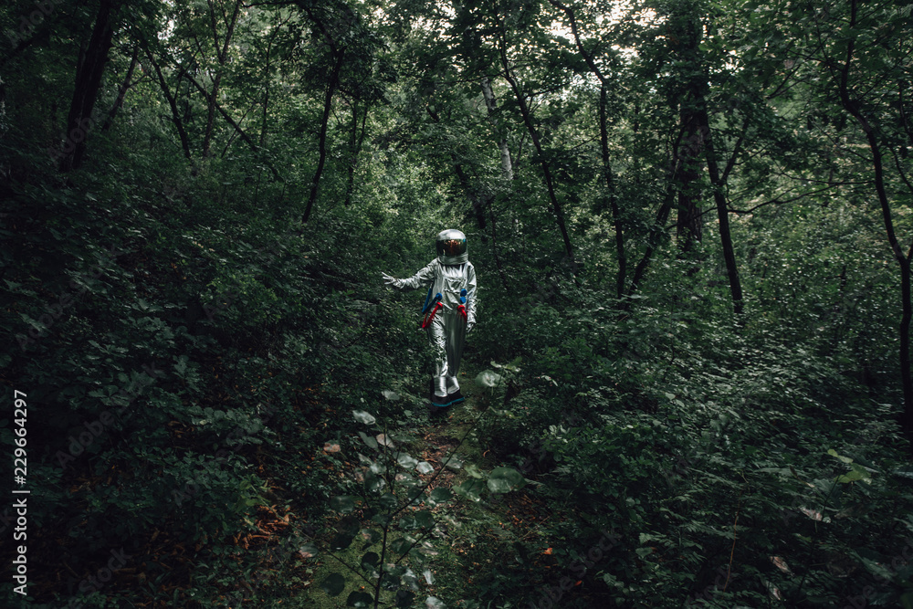 Spaceman walking in forest