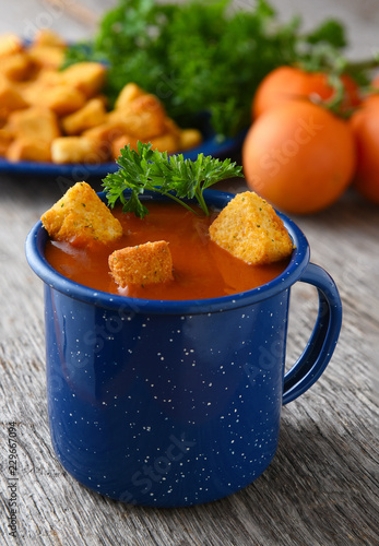 Closeup of a blue mug filled with fresh homemade tomato soup