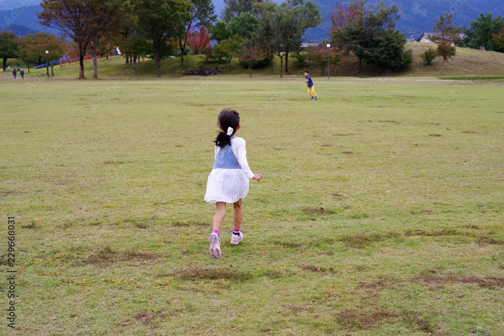 芝生の公園を走る女の子