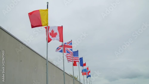 Allied flags flying high on masts above the beaches of Normandy, flags of Canada, United Kingdom, France, United States of America, The Netherlands and Norwegian on masts near Utah beach museum photo