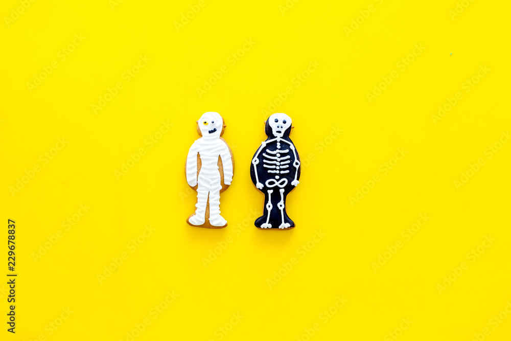 Fototapeta premium Halloween traditions. Halloween gingerbread in shape of evil characters on yellow background top view space for text