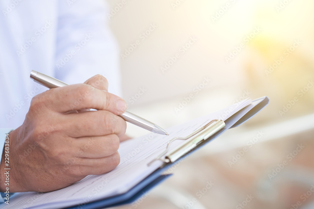 Close-up image of doctor taking notes in medical history of patient - obrazy, fototapety, plakaty 