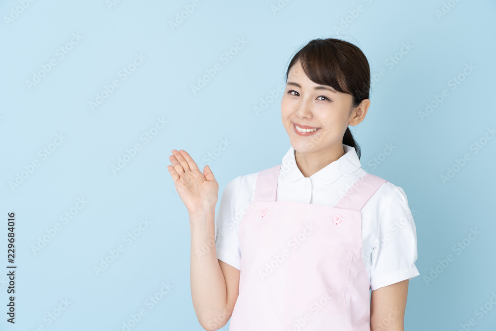portrait of young asian nurse wearing apron on blue background portrait of young asian nurse wearing apron on blue background