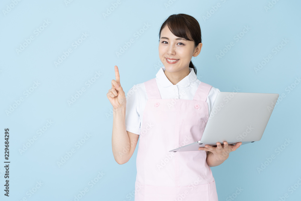 portrait of young asian nurse wearing apron on blue background portrait of young asian nurse wearing apron on blue background