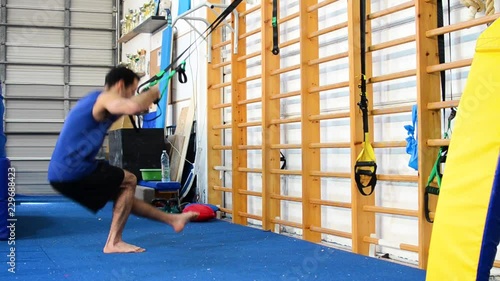 a still shot of a guy doing pistol squats
inside a gymnastics gym photo