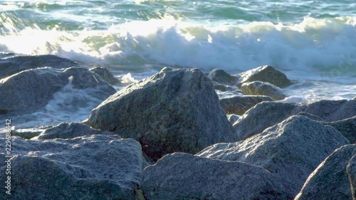 Ocean waves splashing up against rocks in South Florida beach coast landscape photo