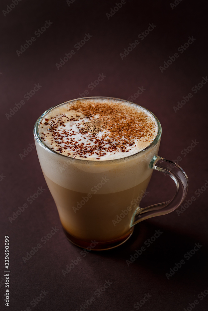 Glass of coffee with chocolate topping on elegant dark brown background Glass of coffee with chocolate topping on elegant dark brown background