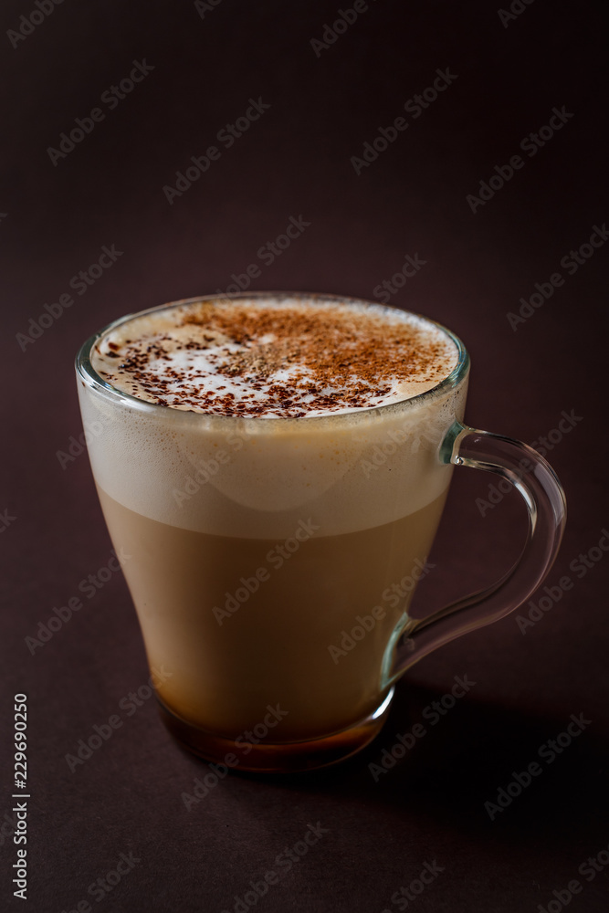 Glass of coffee with chocolate topping on elegant dark brown background Glass of coffee with chocolate topping on elegant dark brown background