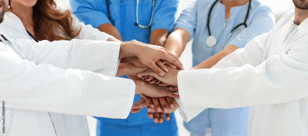 Doctors and nurses stacking hands. concept of mutual aid. - obrazy, fototapety, plakaty 