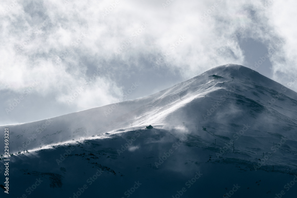 Strong wind gusts carry snow over Peak 8 near dusk in Breckenridge, CO