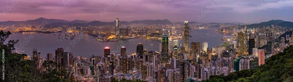 Panorama of Hong Kong Skyline at dusk. Night aerial view of skyscrapers. Lights on the ocean