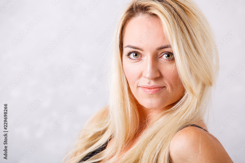 Portrait of young smiling woman on grey background Portrait of young smiling woman on grey background