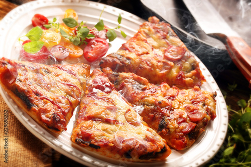 Homemade fresh pizza with tomatoes, cheese and mushrooms on wooden table closeup