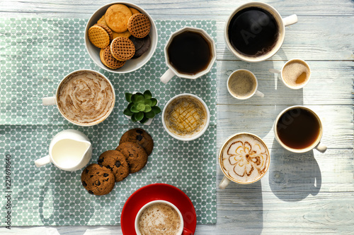 Flat lay composition with cups of tasty aromatic coffee and cookies on wooden background © Pixel-Shot