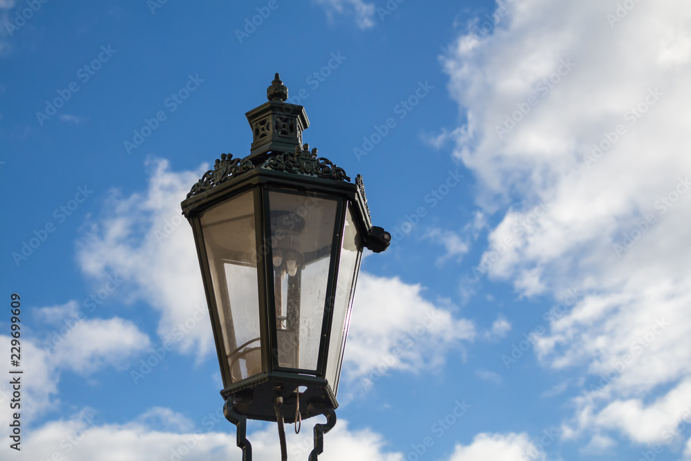 Traditional street lamp - lantern and a blue sky with clouds
