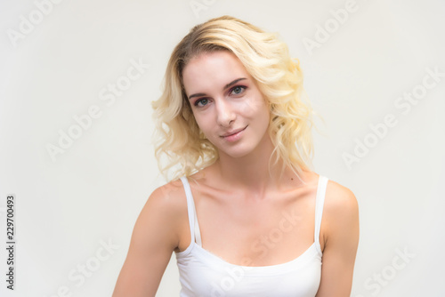 Beauty portrait of a beautiful blonde girl on a white background with perfect makeup.