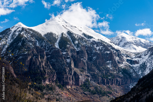 Telluride mountain peaks with blowing snow and pine trees, Autumn, Telluride, USA photo