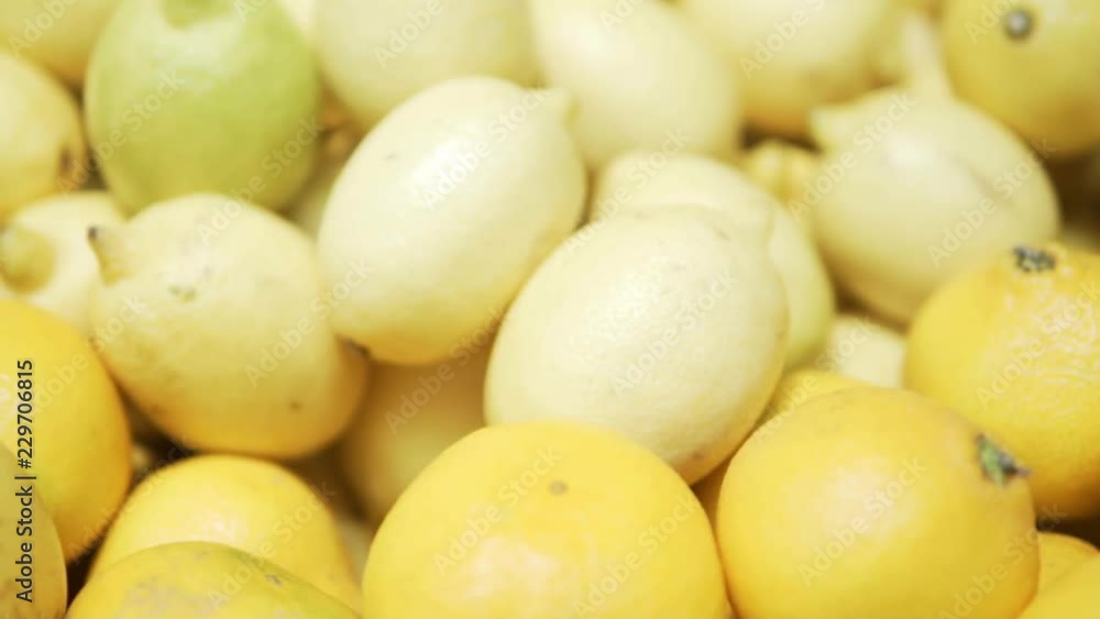 Fruit department in the store. Lots of yellow lemons, then the camera goes to the orange tangerines Fruit department in the store. Lots of yellow lemons, then the camera goes to the orange tangerines